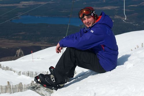 Snowboarder sitting in snow