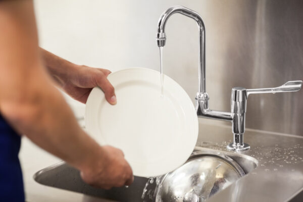 Kitchen porter washing dishes.