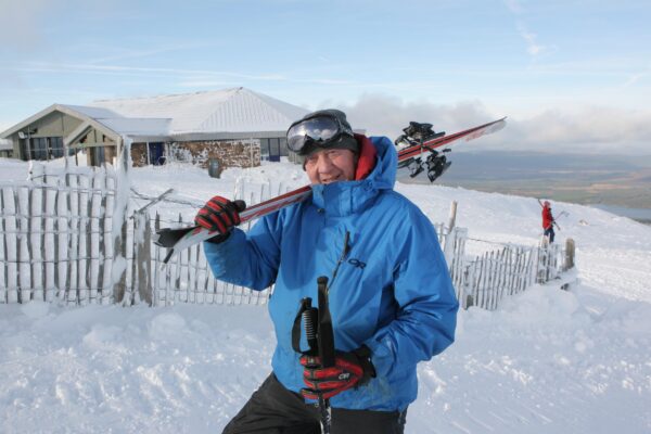 Staff member at Cairngorm Mountain with skis