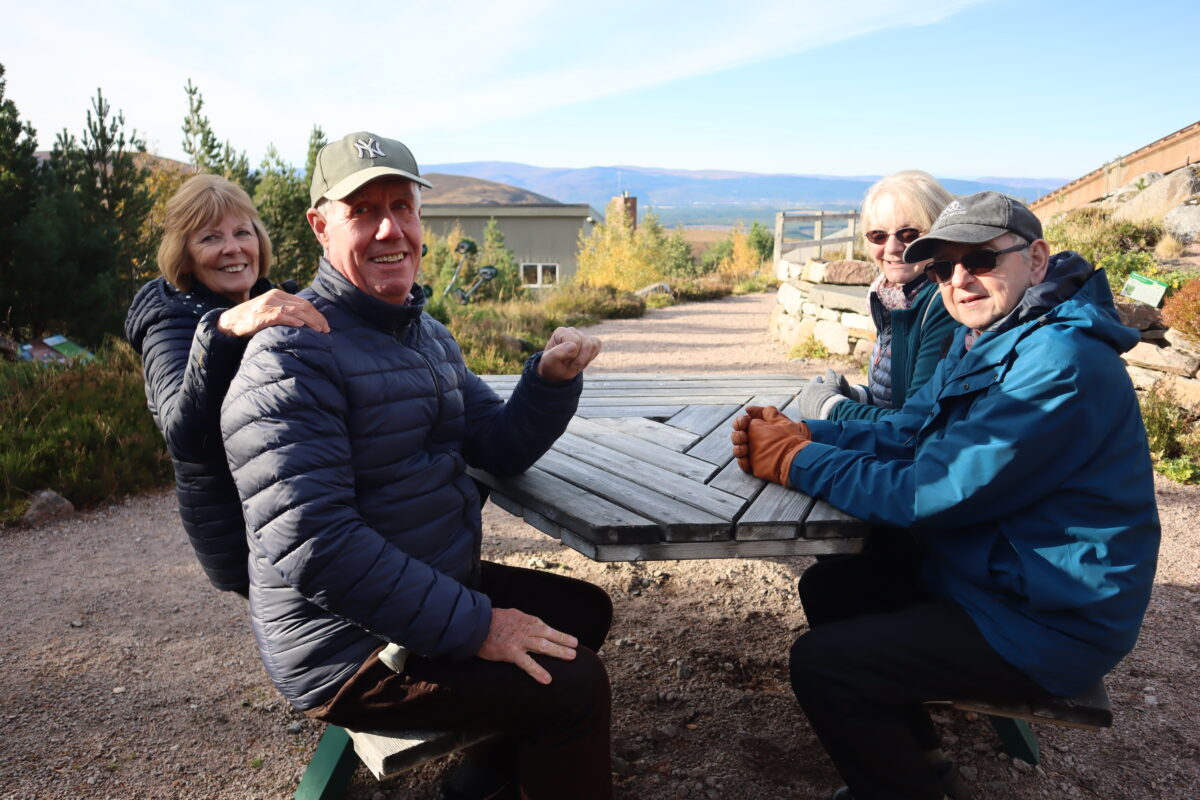 People sitting at a picnic bench at the mountain garden